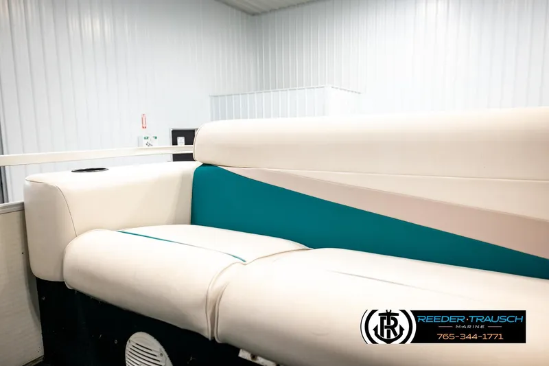Slide: The Image of White and teal seating on a 1998 Godfrey SW2423 boat, in a bright indoor setting. - 30