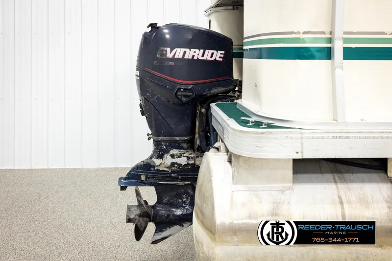 Slide: The Image of Outboard motor on a 1998 Godfrey SW2423 pontoon boat in a showroom setting. - 35