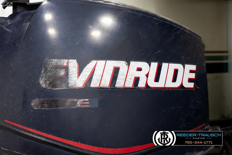 Slide: The Image of Close-up of an Evinrude outboard motor with visible wear and Reeder-Trausch Marine logo. - 36