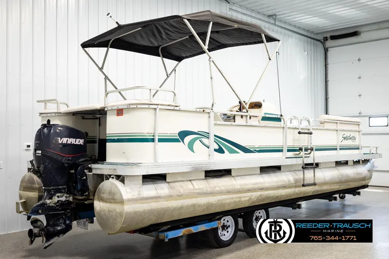 Slide: The Image of 1998 Godfrey SW2423 pontoon boat with Evinrude motor in indoor storage. - 6