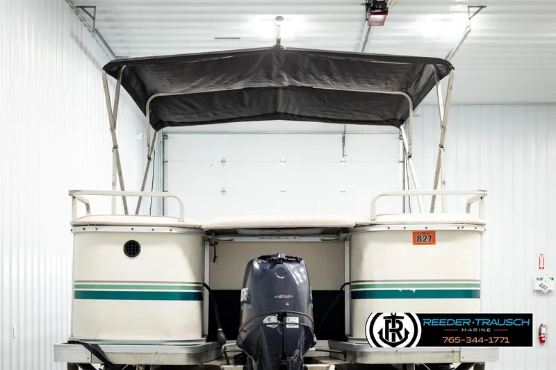 Slide: The Image of 1998 Godfrey SW2423 pontoon boat with canopy in a storage facility. - 7
