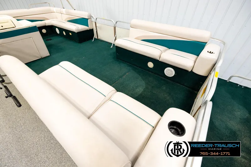 Slide: The Image of Interior of a 1998 Godfrey SW2423 pontoon boat with white and teal seating. - 9