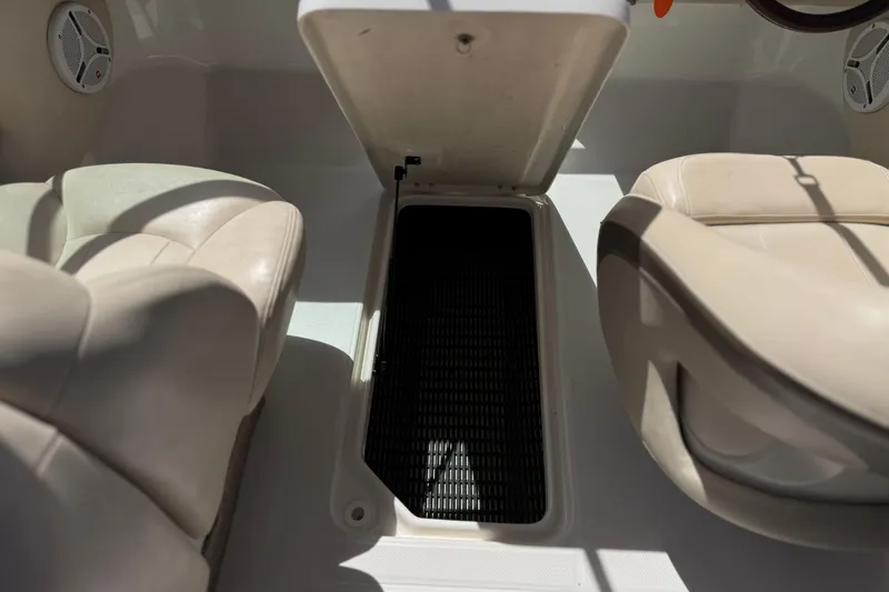 Slide: The Image of 2006 Chaparral 190 SSi boat interior with open storage compartment between seats. - 23
