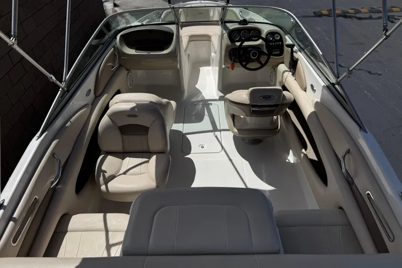 Slide: The Image of Interior view of a 2006 Chaparral 190 SSi boat, featuring beige seating and steering console. - 8