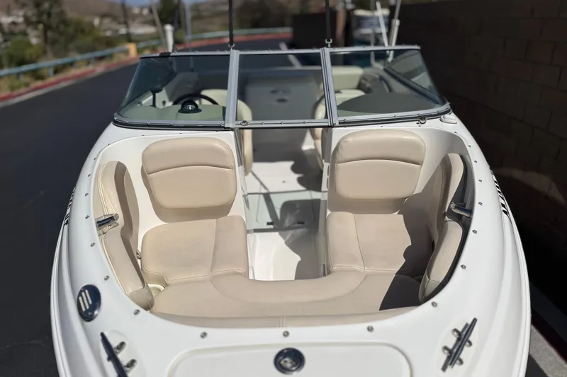 Slide: The Image of 2006 Chaparral 190 SSi boat with beige seating and windshield, parked outdoors. - 9