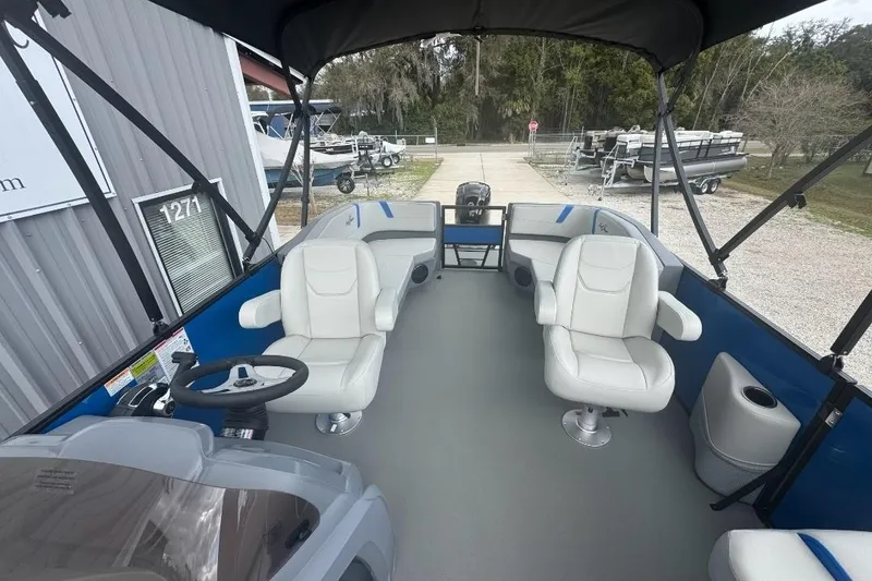 Slide: The Image of 2026 SunChaser Lucerne 20 LR DH pontoon boat interior with white seating and steering console. - 5