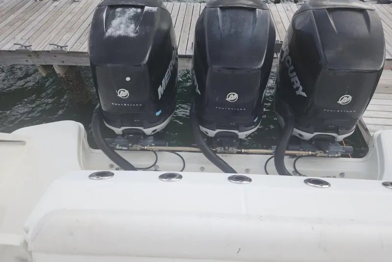 Slide: The Image of Triple Mercury outboard engines on a 2014 Boston Whaler 350 Outrage boat at dock. - 10