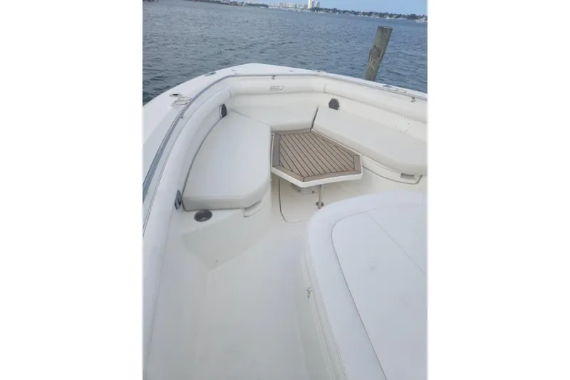 Slide: The Image of 2014 Boston Whaler 350 Outrage boat interior with seating and wooden table. - 20