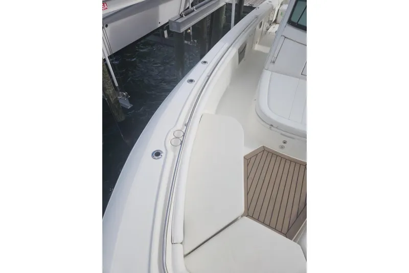 Slide: The Image of 2014 Boston Whaler 350 Outrage boat deck with white seating and wood accents. - 24