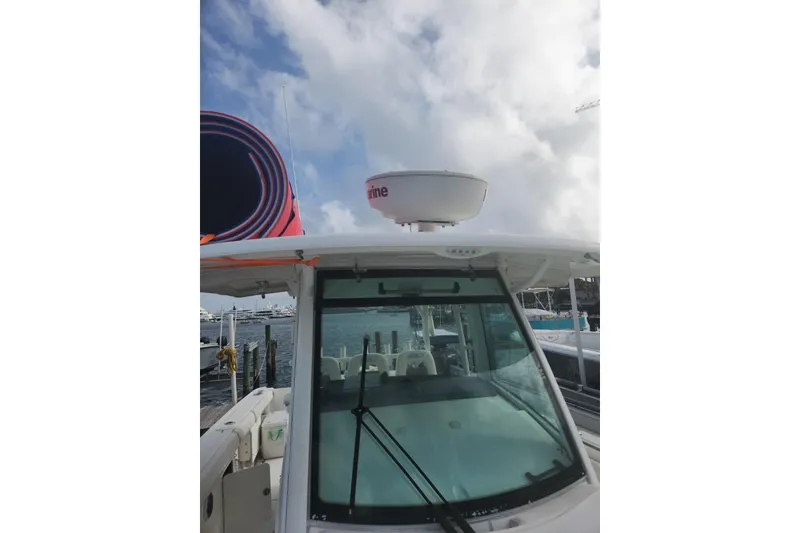 Slide: The Image of 2014 Boston Whaler 350 Outrage boat docked, featuring radar equipment and clear skies. - 39