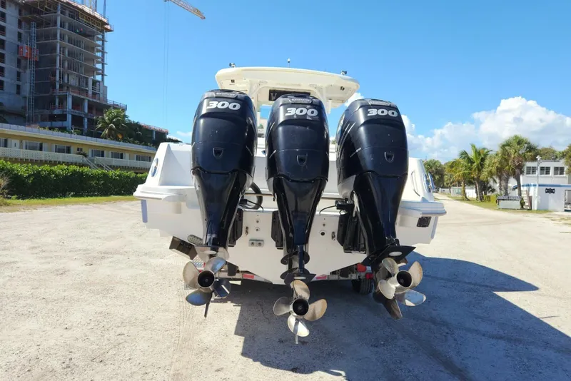 Slide: The Image of 2014 Boston Whaler 350 Outrage with triple 300 horsepower engines, parked outdoors. - 4