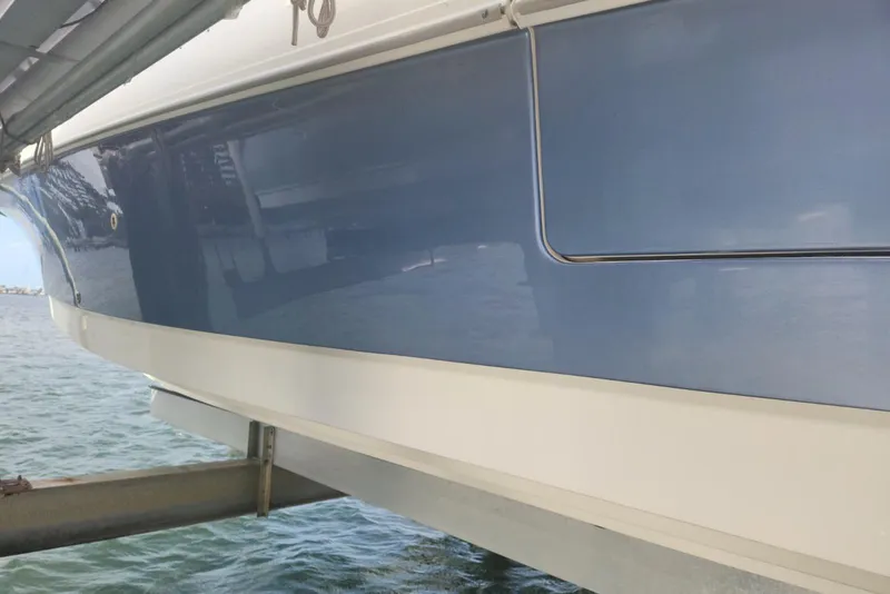 Slide: The Image of 2014 Boston Whaler 350 Outrage boat hull in blue, docked by the water. - 46
