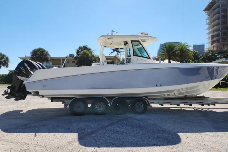 Slide: The Image of 2014 Boston Whaler 350 Outrage boat on trailer, parked outdoors under clear sky. - 6
