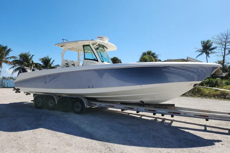 Slide: The Image of 2014 Boston Whaler 350 Outrage boat on trailer, surrounded by palm trees. - 8