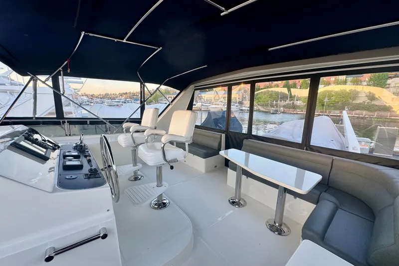 Slide: The Image of Pilothouse interior of 2007 Symbol 59' Classic yacht with helm, seating, and waterfront view. - 10