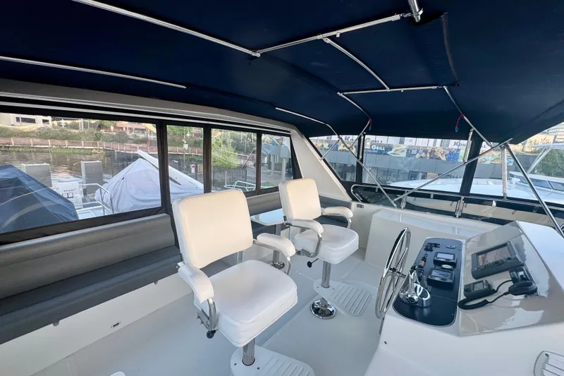 Slide: The Image of 2007 Symbol 59' Pilothouse Classic yacht interior with helm, white chairs, and navigation equipment. - 12