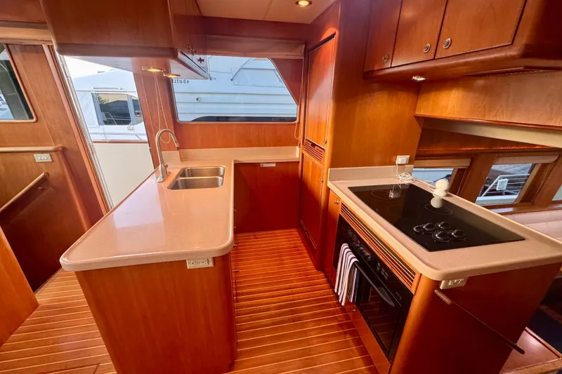 Slide: The Image of Luxurious 2007 Symbol 59' Pilothouse Classic yacht kitchen with modern appliances and wood finish. - 20