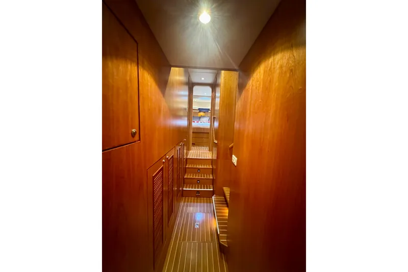Slide: The Image of Wood-paneled hallway inside 2007 Symbol 59' Pilothouse Classic yacht, featuring steps and ambient lighting. - 27
