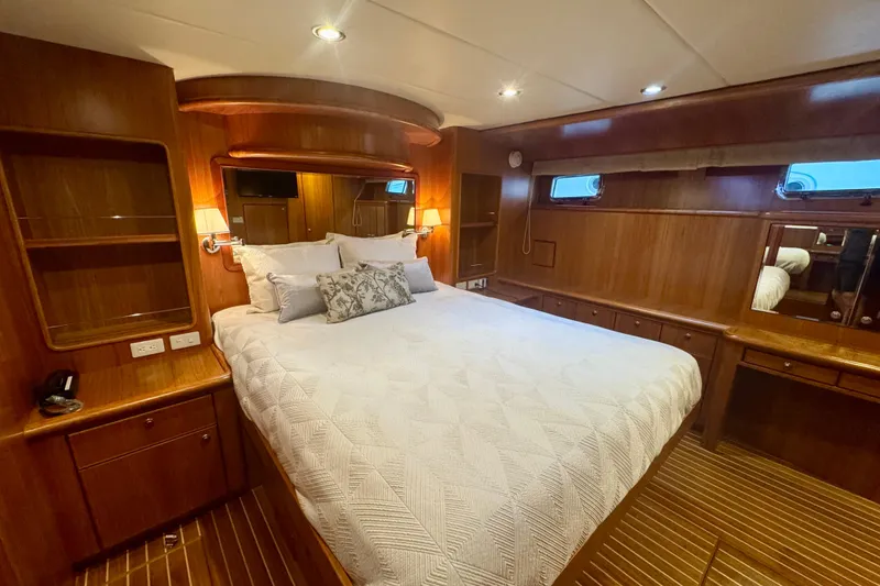 Slide: The Image of Luxurious 2007 Symbol 59' Pilothouse Classic yacht bedroom with elegant wood finish. - 28