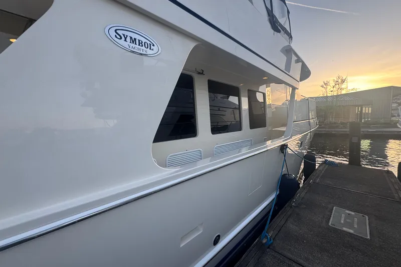 Slide: The Image of 2007 Symbol 59' Pilothouse Classic yacht docked at sunset, showcasing sleek design and elegance. - 3