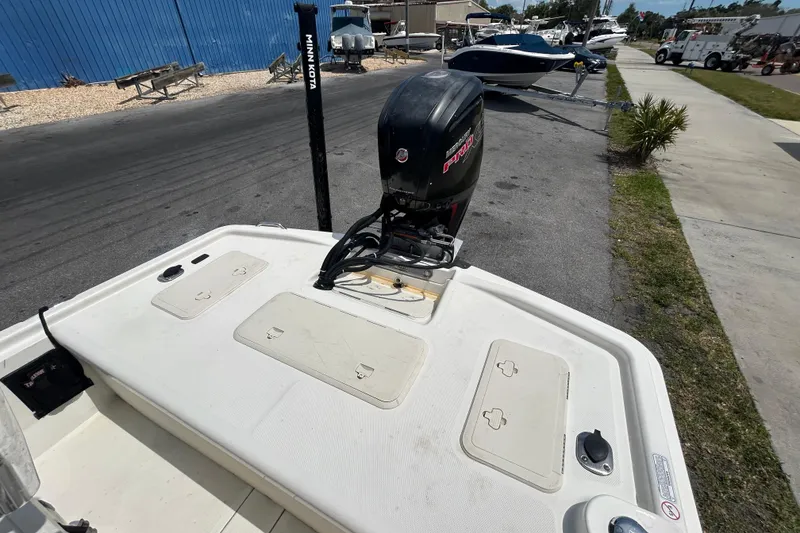 Slide: The Image of 2021 Mako Pro Skiff 19 CC boat with outboard motor in a marina setting. - 11
