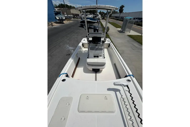 Slide: The Image of 2021 Mako Pro Skiff 19 CC boat with center console and trolling motor, docked outdoors. - 16