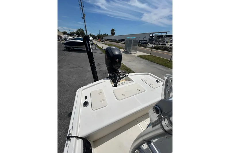 Slide: The Image of 2021 Mako Pro Skiff 19 CC boat with outboard motor, docked under clear skies. - 7