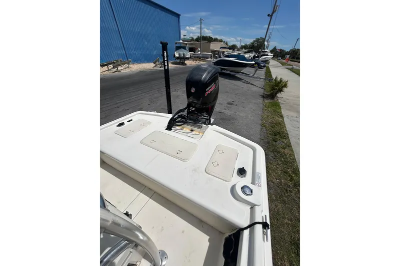 Slide: The Image of 2021 Mako Pro Skiff 19 CC boat with outboard motor in a marina setting. - 8