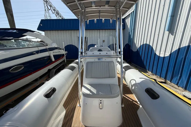 Slide: The Image of 2018 Ribcraft 7.8 boat with center console, docked beside a blue and white building. - 12