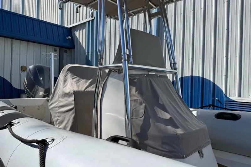 Slide: The Image of 2018 Ribcraft 7.8 boat with covered console, docked near a metal building. - 15