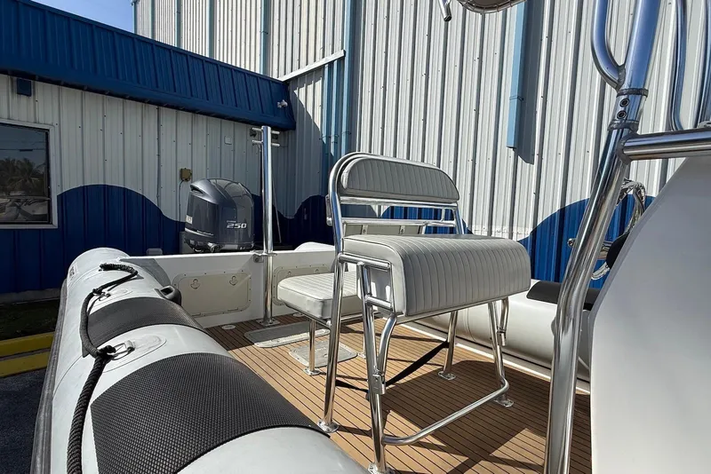 Slide: The Image of 2018 Ribcraft 7.8 boat with Yamaha 250 engine, docked near a blue and white building. - 3