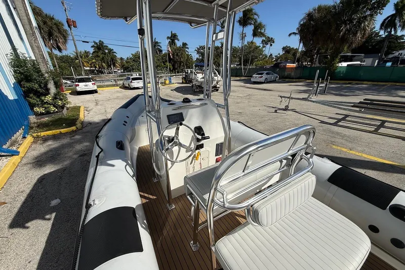 Slide: The Image of 2018 Ribcraft 7.8 boat with steering console and seating, parked outdoors. - 7