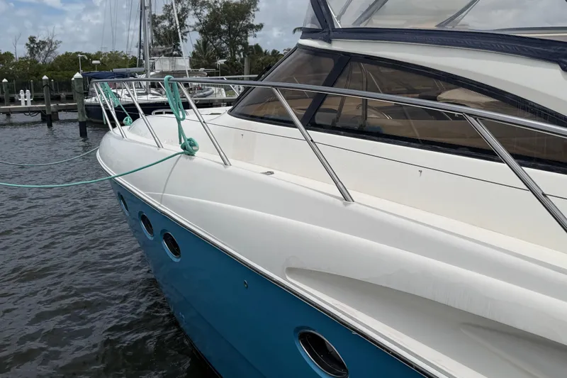 Slide: The Image of 2003 Viking Princess V50 yacht docked, featuring sleek design and blue hull. - 28