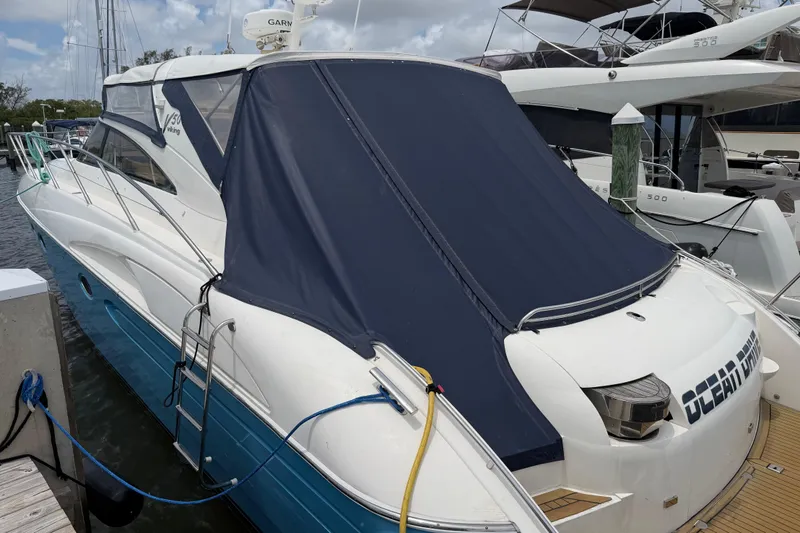Slide: The Image of 2003 Viking Princess V50 yacht docked, featuring a blue cover and sleek design. - 30