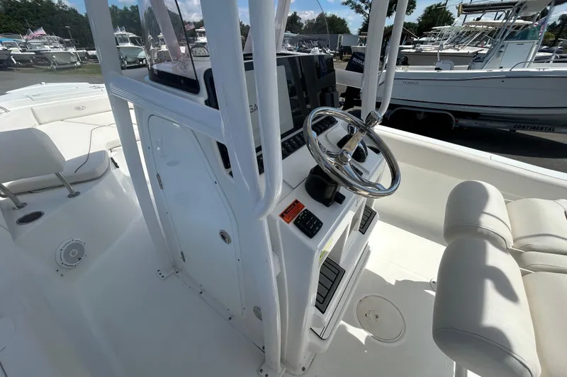 Slide: The Image of 2021 Sea Hunt Ultra 234 boat interior with steering wheel and seating. - 20