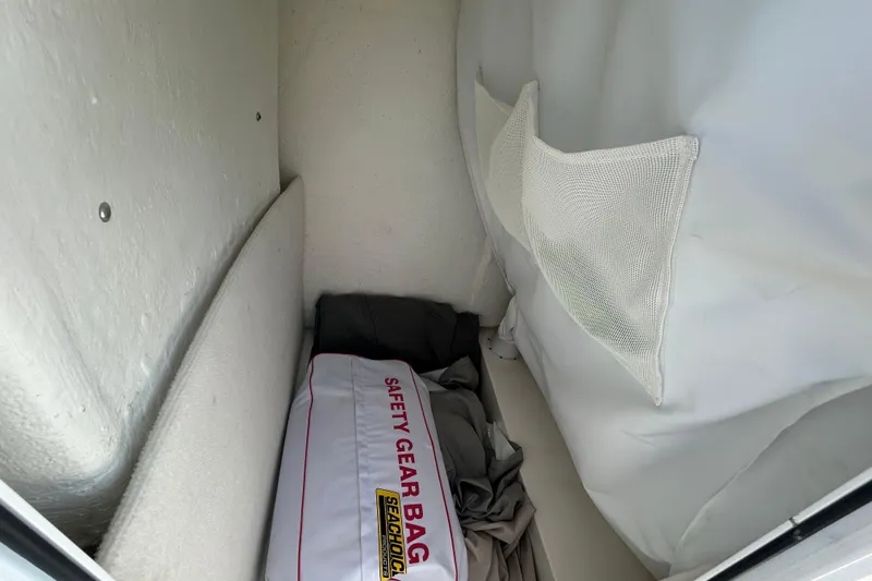 Slide: The Image of Storage compartment in a 2021 Sea Hunt Ultra 234 boat with safety gear bag. - 21