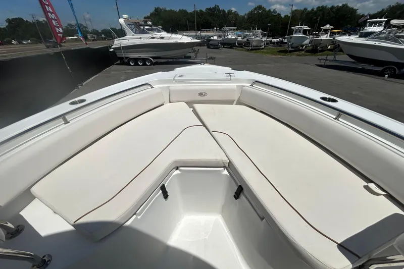 Slide: The Image of 2021 Sea Hunt Ultra 234 boat with spacious white seating area, docked outdoors. - 23