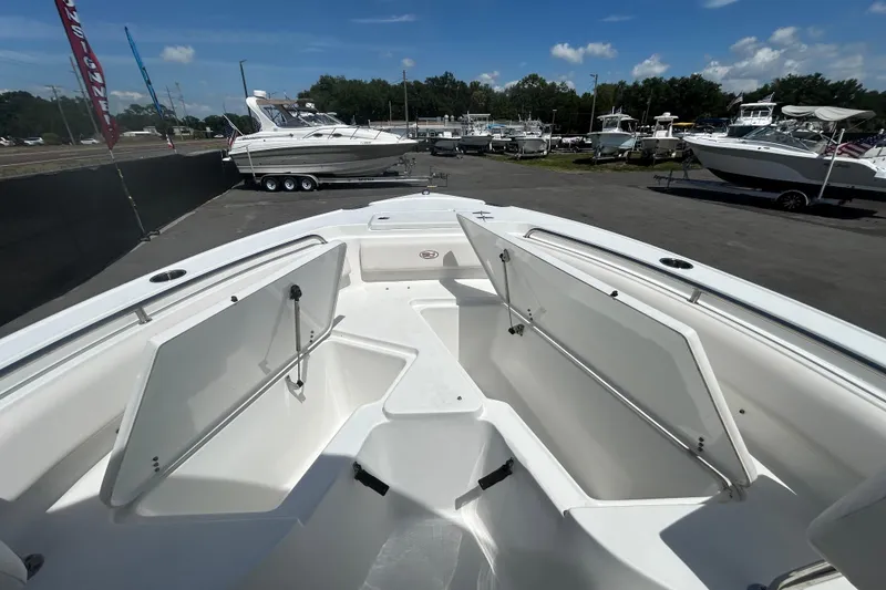 Slide: The Image of 2021 Sea Hunt Ultra 234 boat with open storage compartments, displayed outdoors. - 24