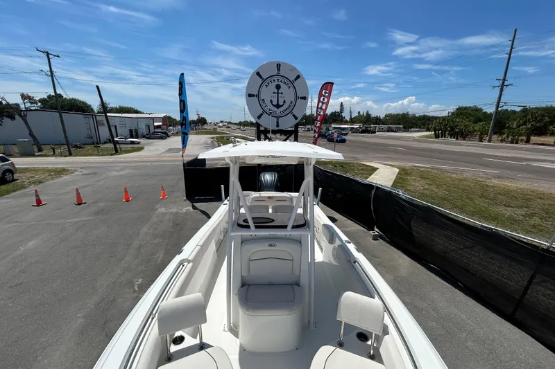 Slide: The Image of 2021 Sea Hunt Ultra 234 boat displayed outdoors under clear blue sky. - 26