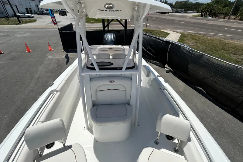 Slide: The Image of 2021 Sea Hunt Ultra 234 boat interior with seating and console, parked on pavement. - 29