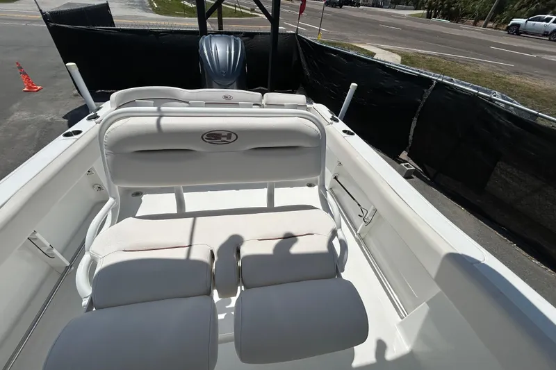 Slide: The Image of 2021 Sea Hunt Ultra 234 boat interior with white seating and motor view. - 36