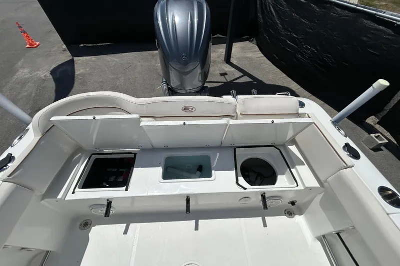 Slide: The Image of 2021 Sea Hunt Ultra 234 boat interior with storage compartments and engine view. - 39