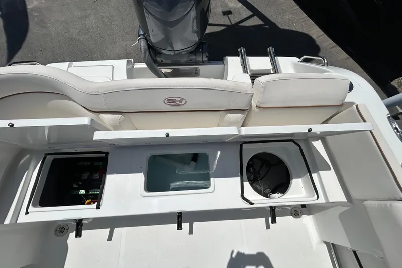 Slide: The Image of 2021 Sea Hunt Ultra 234 boat interior with storage compartments and seating. - 40