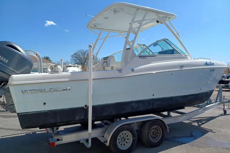 Slide: The Image of 2020 World Cat 230 DC boat on trailer, side view under clear blue sky. - 34