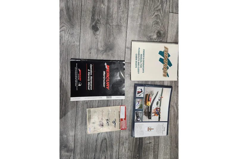 Slide: The Image of Manuals and brochures for 2012 Rinker 216 Captiva Bowrider on wooden floor. - 11