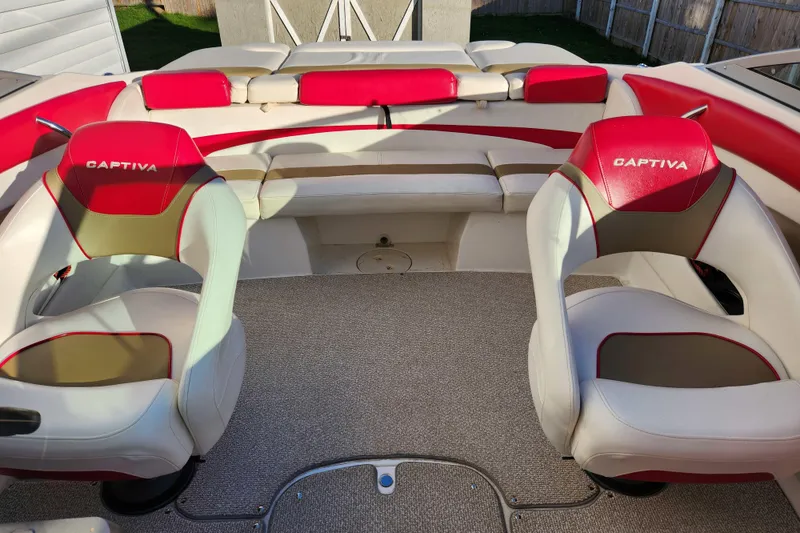 Slide: The Image of 2012 Rinker 216 Captiva Bowrider interior with red and beige seating. - 4