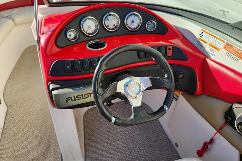 Slide: The Image of 2012 Rinker 216 Captiva Bowrider dashboard with red accents and steering wheel. - 8