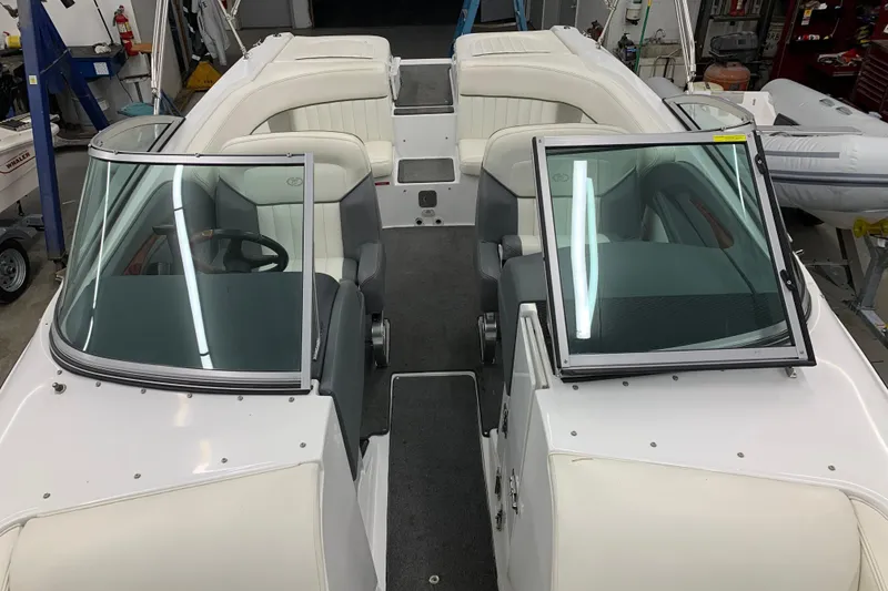 Slide: The Image of 2007 Cobalt 262 boat interior with white seating and dual windshields in a workshop setting. - 25