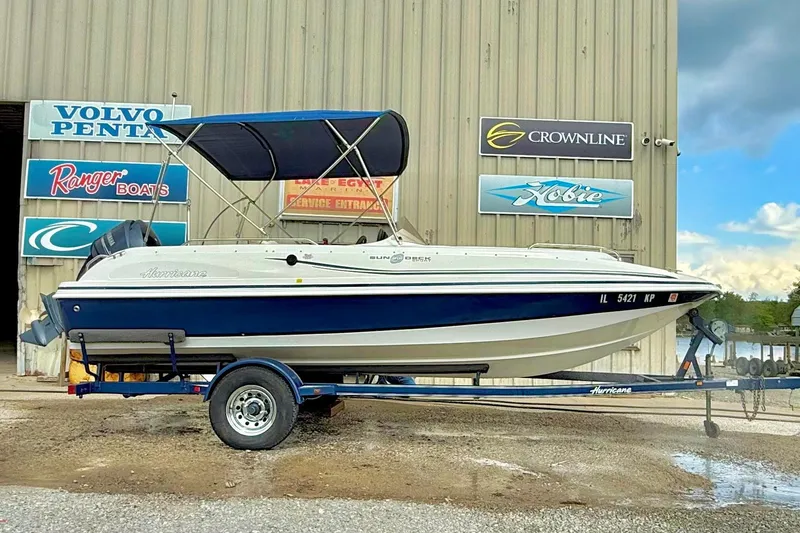 The Image of 2013 Hurricane SunDeck Sport 201 OB boat on trailer, parked outside marine shop. - 1