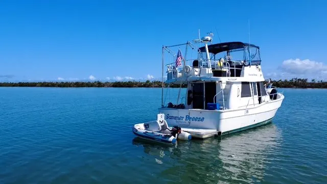 Slide: The Image of 2001 Mainship 390 Trawler on calm water, blue sky. - 13